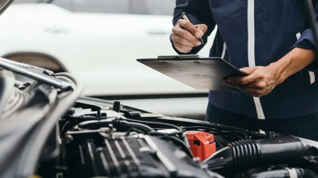 Mechanic performing a VSSI Inspection on a vehicle at Chase autobody.